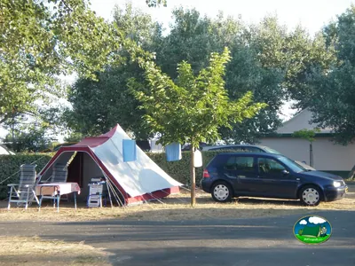 parcela con tienda de campaña, mesa y coche aparcado bajo los árboles en Gujan-Mestras