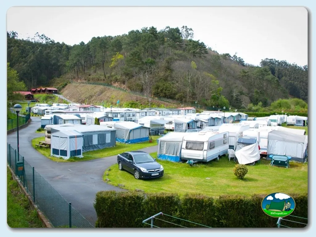 Parcelas con caravanas y tiendas de acampada, montaña al fondo del Camping San Pedro de la Ribera, Soto de Luiña (Asturias)