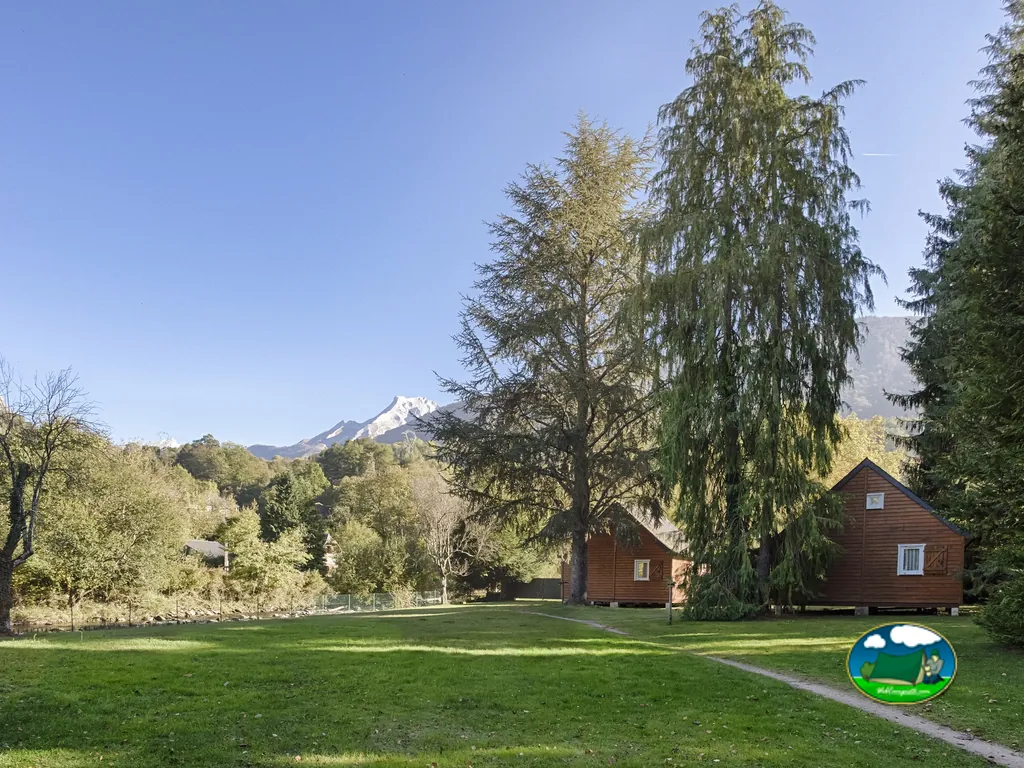 cabañas de madera y prado con vistas a montañas nevadas de los Pirineos en Laruns