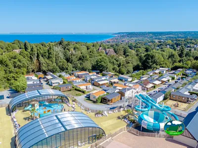 vista aérea del camping en Villers-sur-Mer con piscina cubierta, toboganes y el mar al fondo