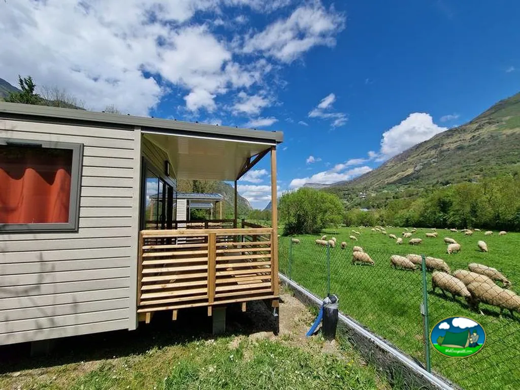 mobile home junto a un prado con ovejas pastando y montañas al fondo en Laruns