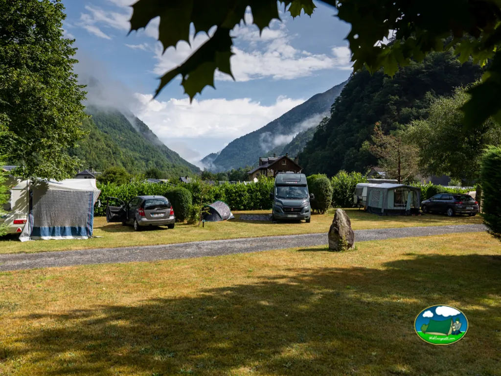 parcelas de acampada con coche, tienda y autocaravana en un valle con niebla en Cauterets