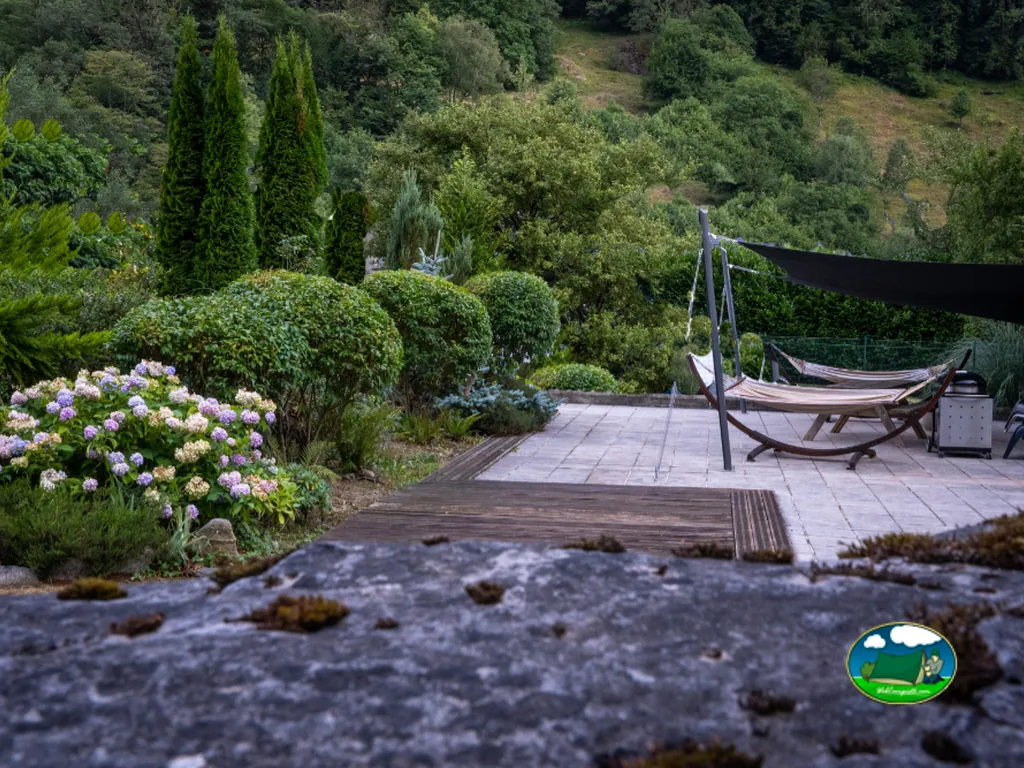 terraza con hamacas e hortensias con vistas a la ladera boscosa en Cauterets