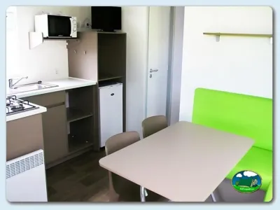 Mobil-home interior con cocina y zona de comedor del Camping Las Gaviotas, Santa María del Mar (Asturias)