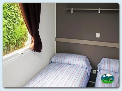 Mobil-home dormitorio con dos camas y ventana del Camping Las Gaviotas, Santa María del Mar (Asturias)