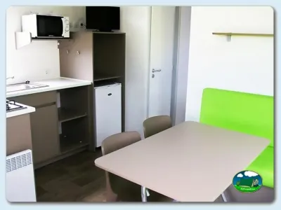 Mobil-home interior con cocina y zona de comedor del Camping Las Gaviotas, Santa María del Mar (Asturias)