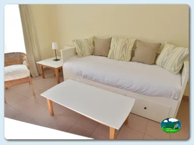 Bungalow interior con cama doble y sala de estar del Camping Las Gaviotas, Santa María del Mar (Asturias)