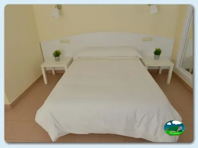 Habitación con cama doble y mesitas del Camping Las Gaviotas, Santa María del Mar (Asturias)