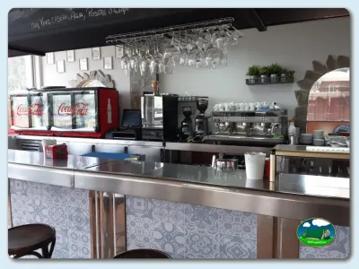 Restaurante bar con cafetera espresso y nevera Coca-Cola del Camping Las Gaviotas, Santa María del Mar (Asturias)