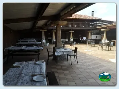 Restaurante con terraza cubierta y mesas de comedor del Camping Las Gaviotas, Santa María del Mar (Asturias)