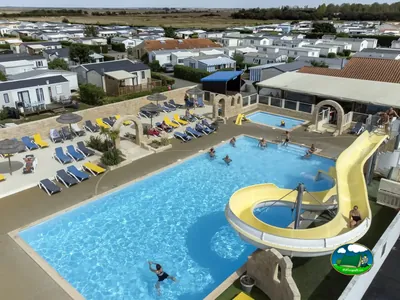 vista aérea de la piscina con tobogán y tumbonas llenas de bañistas en La Tranche-sur-Mer