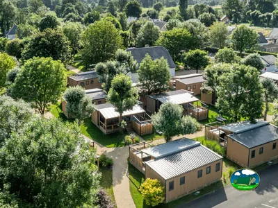 vista aérea de los bungalós de madera entre árboles del camping en Lau-Balagnas