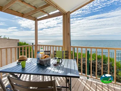 mesa de desayuno en la terraza de un mobil-home frente al mar en Martigues
