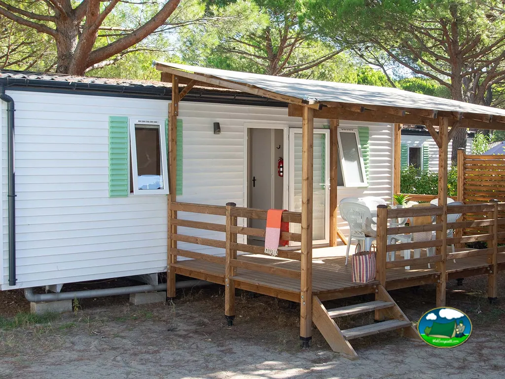 terraza de un mobil-home con mesa y sillas bajo los pinos en el camping de La Grande-Motte