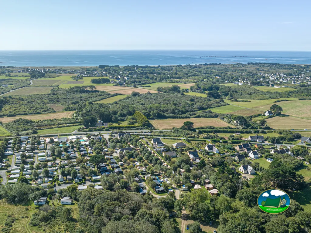 vista aérea del camping entre campos y arbolado con el mar al fondo en Penmarch