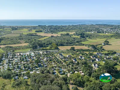 vista aérea del camping entre campos y arbolado con el mar al fondo en Penmarch