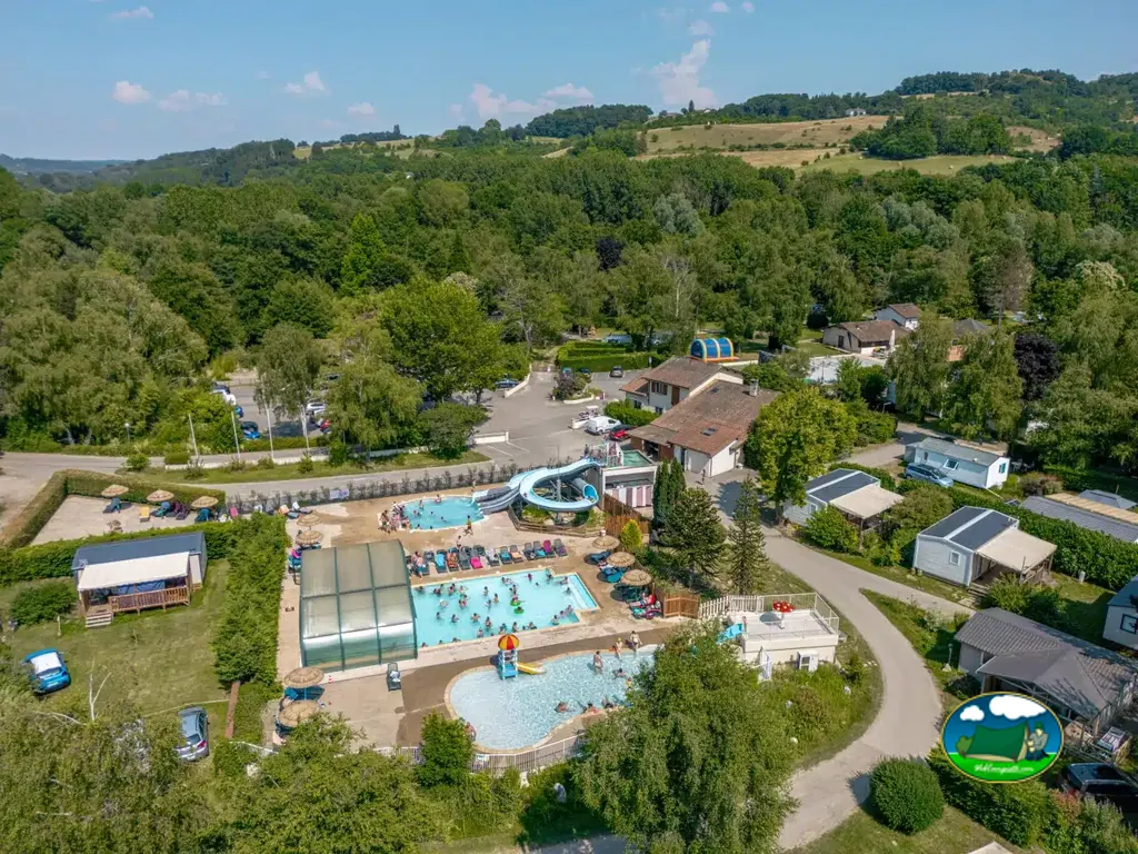 vista aérea del recinto de piscinas con piscina cubierta y solárium junto al aparcamiento en Vernioz