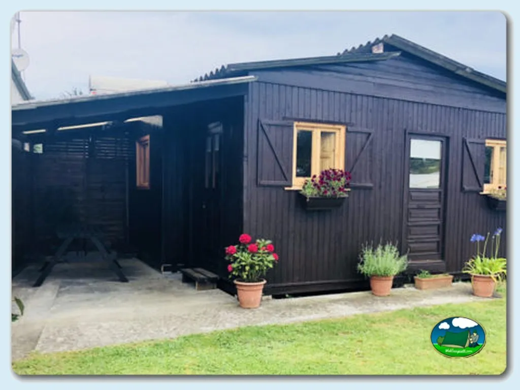 Mobil-home con terraza y flores del Camping Fin de Siglo, Rodiles (Asturias)