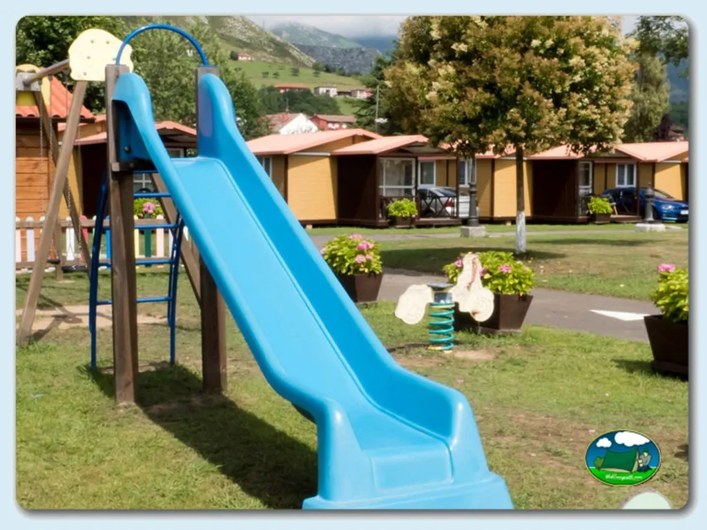 Parque infantil con tobogán azul y vistas a la montaña del Camping Sella, Arriondas (Asturias)