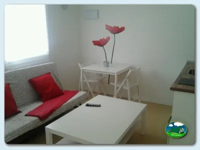 Interior de mobil-home con sofá y zona de comedor del Camping Playa Sauces, Ribadesella (Asturias)