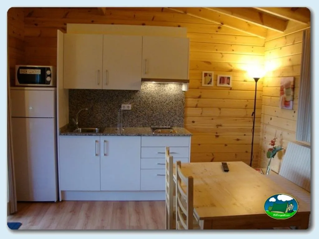 Cabaña interior con cocina equipada y mesa de comedor del Camping Ribadesella, Ribadesella (Asturias)