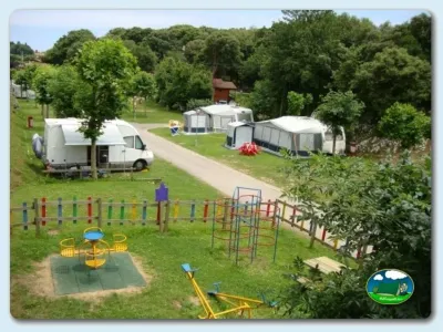 Parcela con cabaña y parque infantil en entorno arbolado del Camping Ribadesella, Ribadesella (Asturias)
