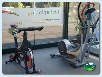 Sala de fitness con bicicleta estática y máquina de ejercicio del Camping Ribadesella, Ribadesella (Asturias)