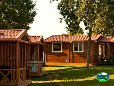 Bungalow de madera con terraza y vistas al jardín arbolado del Camping Palacio de Garaña, Garaña de Pria (Asturias)
