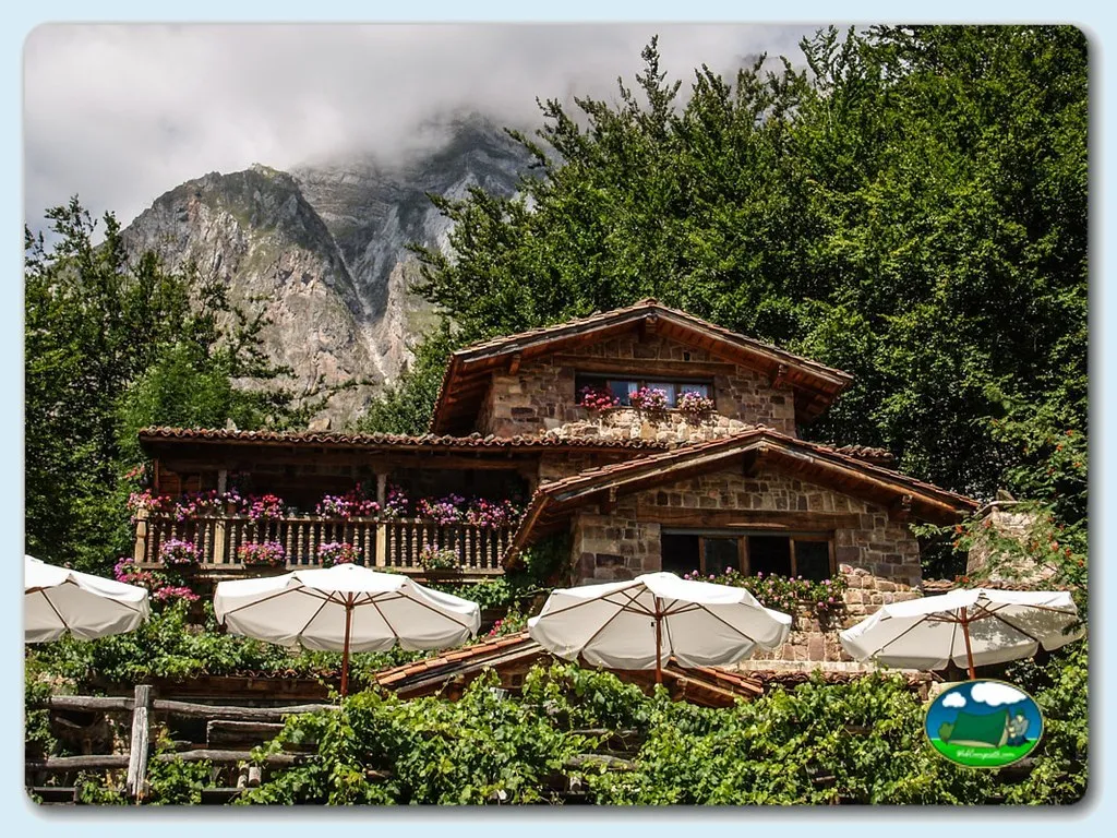 Glamping con vistas a la montaña, terraza con sombrillas del Camping El Redondo Picos de Europa, Fuente Dé (Cantabria)