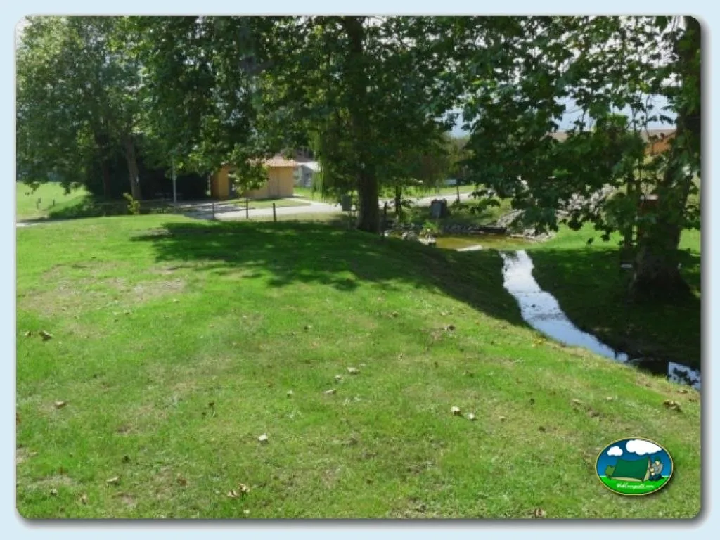 Parcela junto al río con árboles frondosos del Camping Colombres, Colombres en Ribadedeva (Asturias)