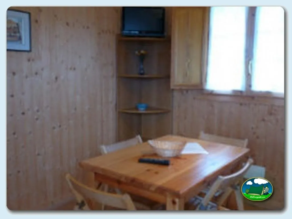 Interior cabaña con mesa de madera del Camping Colombres, Colombres en Ribadedeva (Asturias)