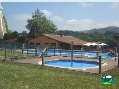 Piscina con vistas a la montaña y edificio principal del Camping Colombres, Colombres en Ribadedeva (Asturias)