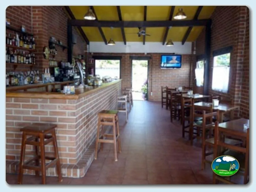 Restaurante bar con barra de ladrillo y mesas de madera del Camping Colombres, Colombres en Ribadedeva (Asturias)