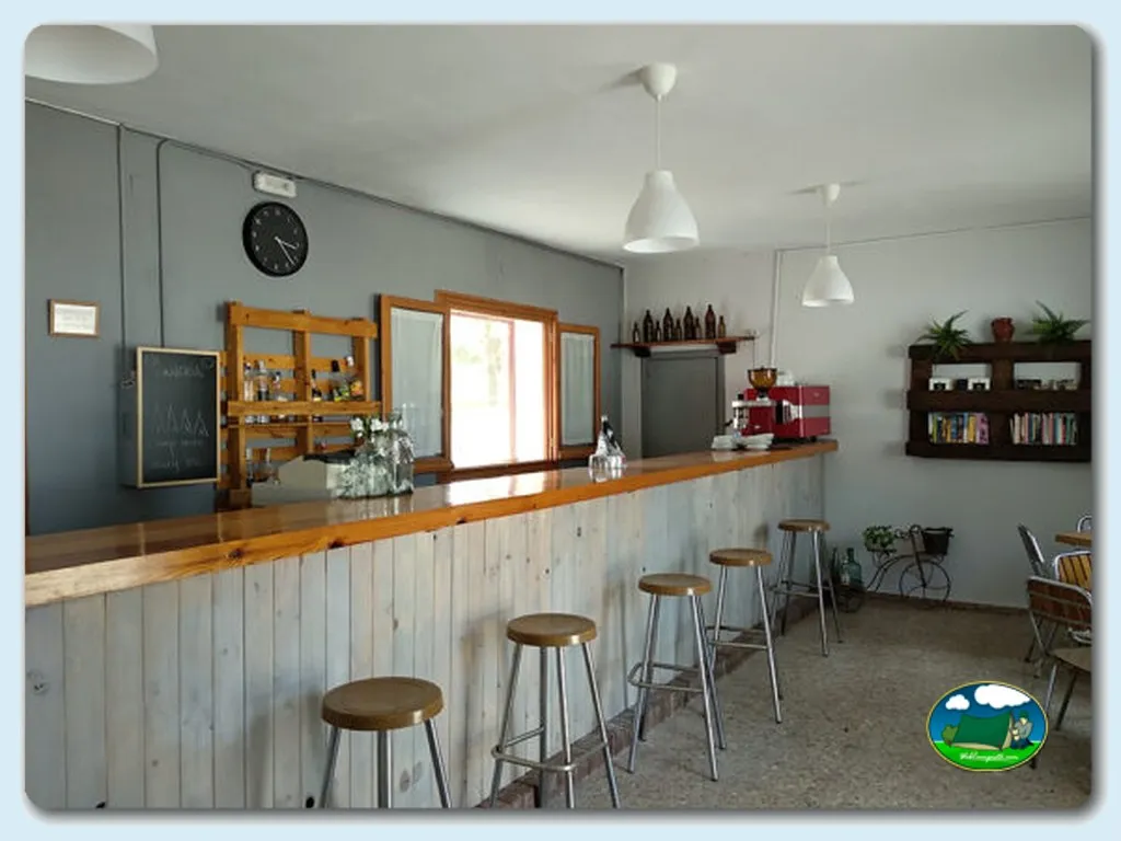 Restaurante bar con barra de madera y taburetes del Camping El Acueducto, Segovia (Segovia)