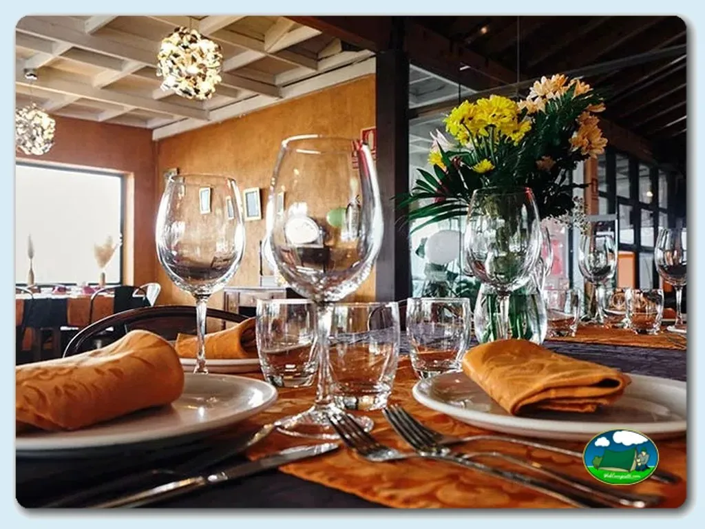 Restaurante con mesa elegantemente preparada y flores frescas del Camping Cavia, Cavia (Burgos)