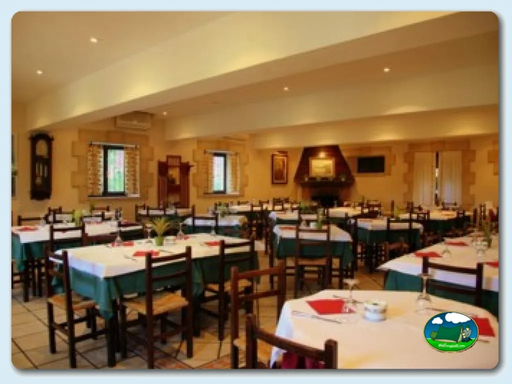 Restaurante interior con mesas y sillas de madera del Camping Santillana del Mar, Santillana del Mar (Cantabria)