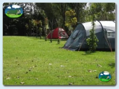 Parcela con tiendas de acampada y mobil-home en entorno arbolado del Camping Virgen del Mar, Santander (Cantabria)