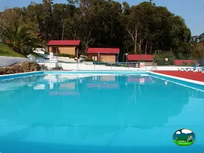 Piscina con bungalows y entorno arbolado del Camping Cabo Mayor, Santander (Cantabria)