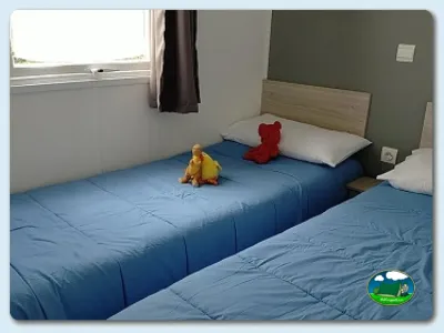 Bungalow interior con camas y juguetes infantiles del Camping Somo Parque, Ribamontán al Mar (Cantabria)