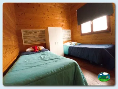 Cabaña interior con dos camas y madera del Camping Somo Parque, Ribamontán al Mar (Cantabria)