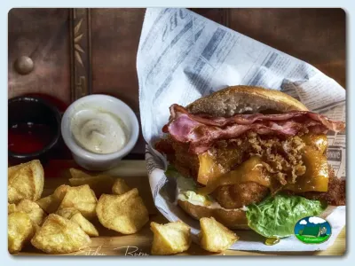 Plato de comida con sándwich, patatas y salsas del Camping Somo Parque, Ribamontán al Mar (Cantabria)