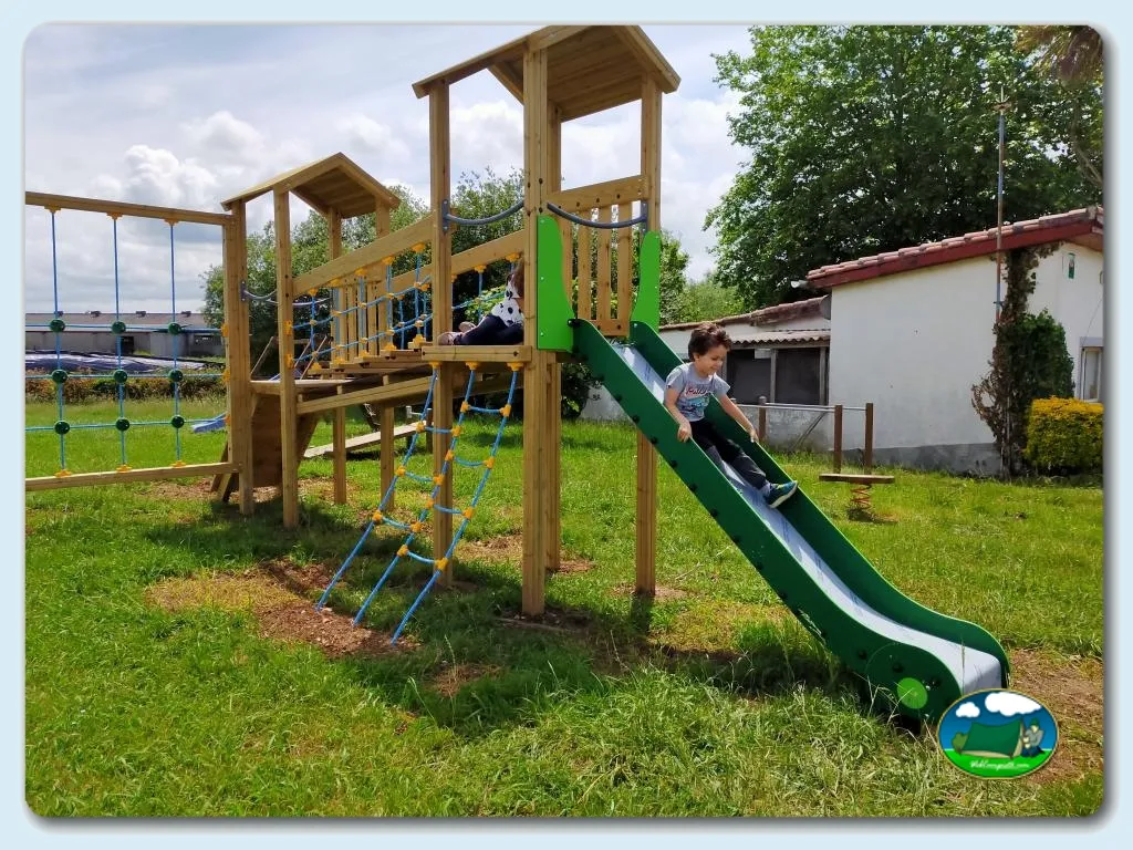Parque infantil con tobogán y estructuras de madera del Camping Somo Parque, Ribamontán al Mar (Cantabria)