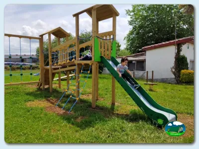 Parque infantil con tobogán y estructuras de madera del Camping Somo Parque, Ribamontán al Mar (Cantabria)