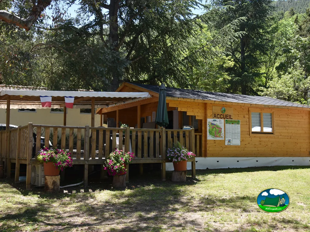 recepción de madera con macetas de flores y montañas al fondo en Corneilla-de-Conflent