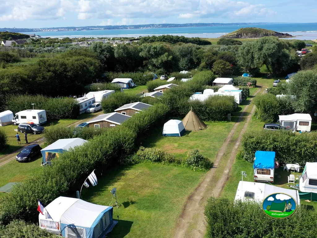 vista aérea de las parcelas con tiendas y caravanas entre setos junto al mar en Ploéven