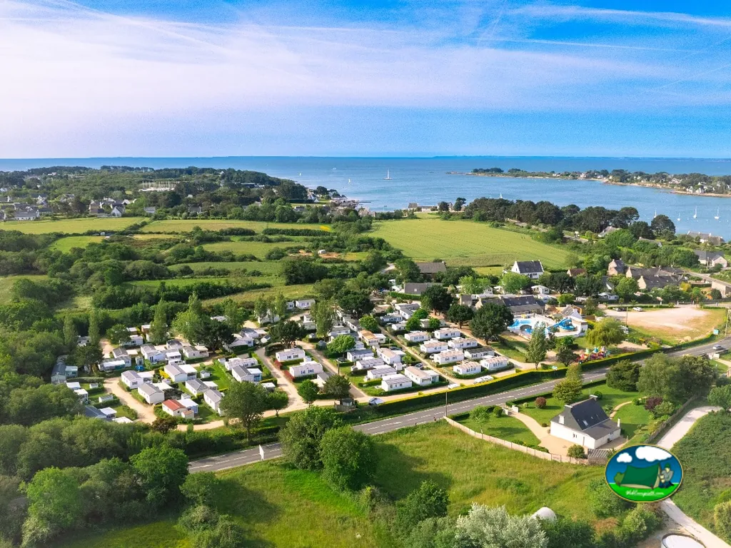 vista aérea de las casas móviles del camping junto a la costa y el pueblo en Saint-Philibert