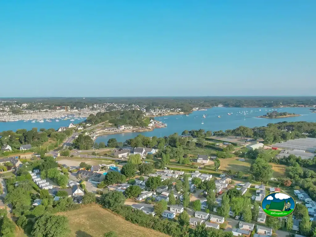 vista aérea de la ría con el camping y su piscina en primer término y el pueblo al fondo