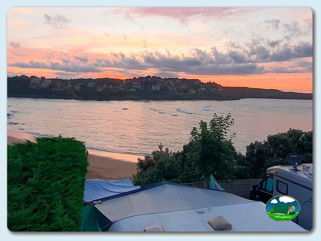 Playa junto al mar con vistas al atardecer desde parcela del Camping Playa la Arena, Isla (Cantabria)