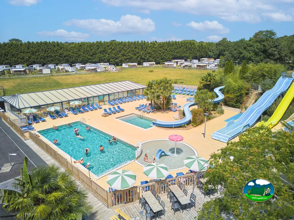vista aérea de la piscina con toboganes, tumbonas y bañistas rodeada de casas móviles en Monterblanc