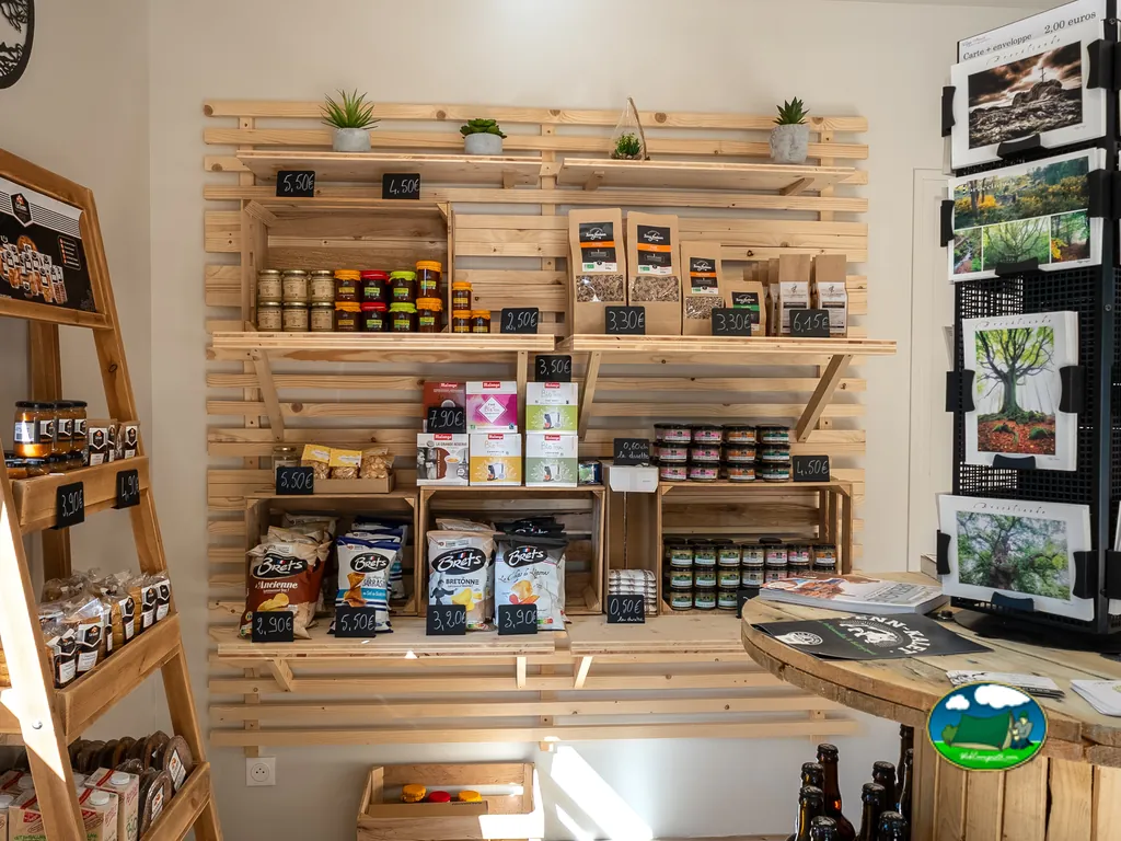 estantería de la tienda del camping con productos locales, mermeladas y patatas fritas con precios en Saint-Malo-de-Beignon